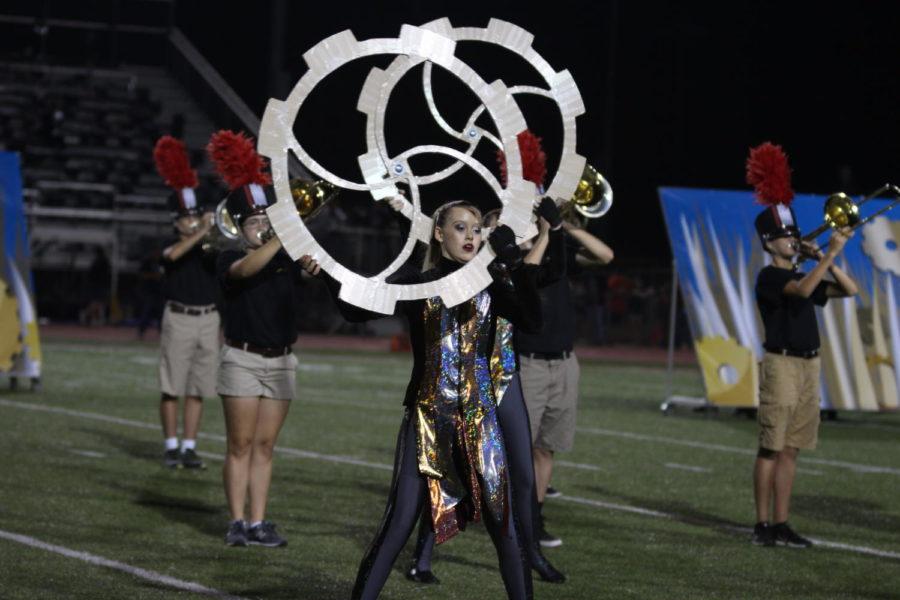 Color guard holds steampunk gears as part of the Metamorphosis story. 