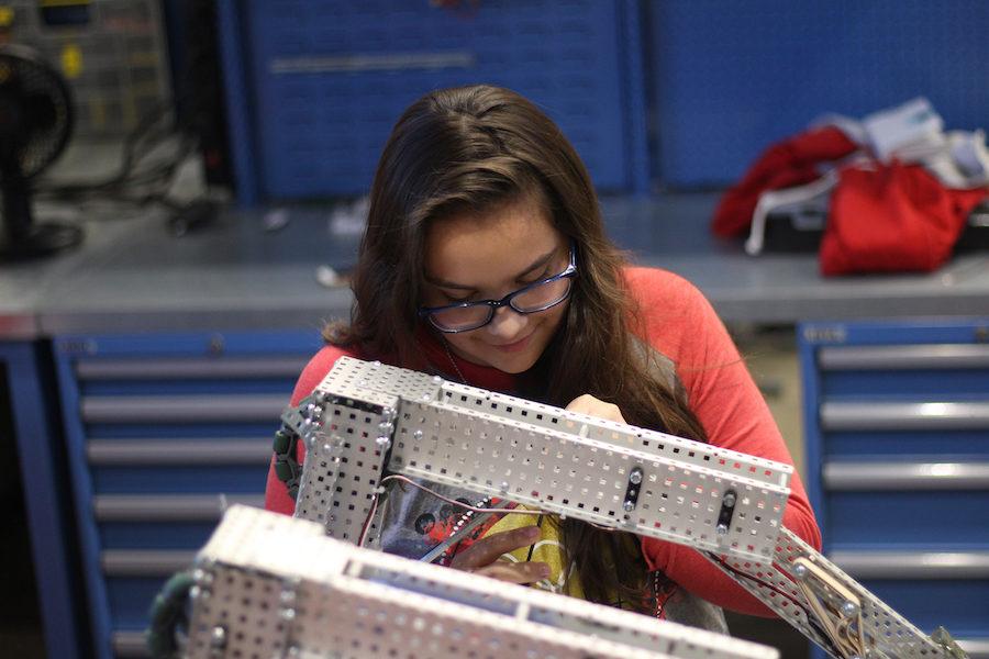 Freshman Madilyn Calderon tinkers with her robot in class.