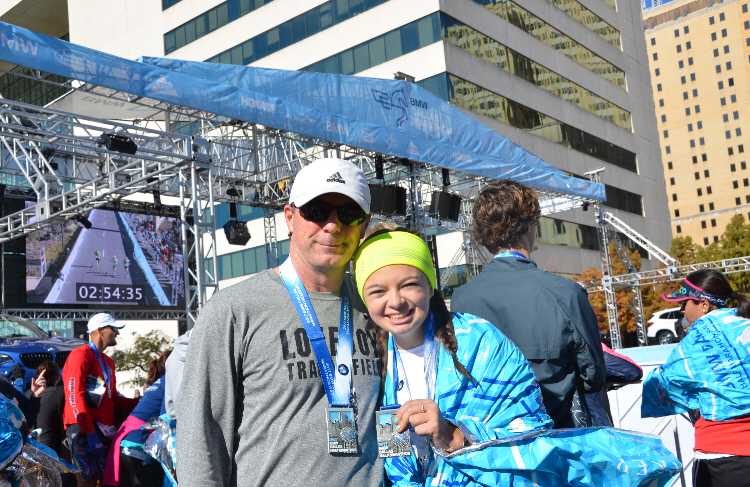 Junior Evie McGowan and her father, Barry McGowan, pose for a picture with their medals from the BMW Dallas Half Marathon.