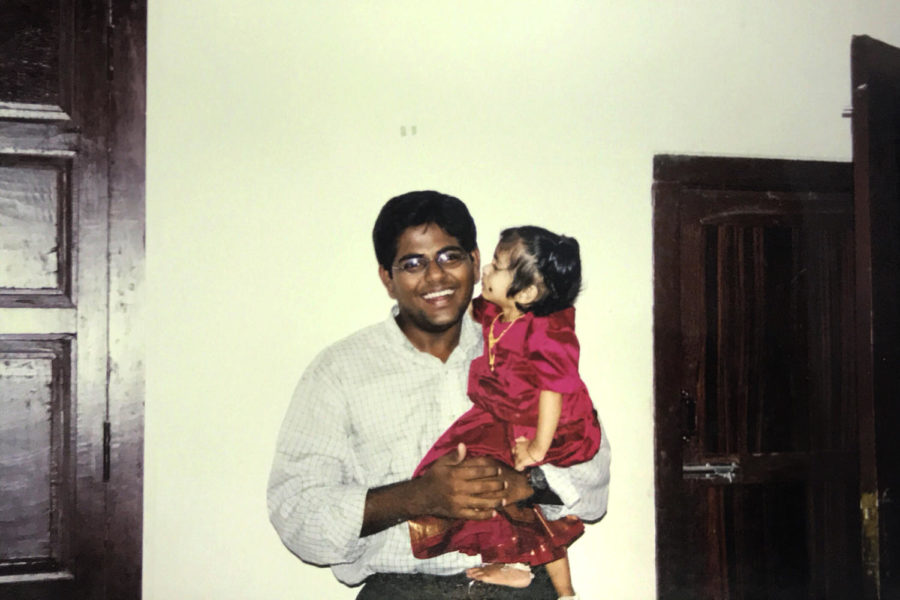 Radhakrishnans uncle smiles as he holds her.