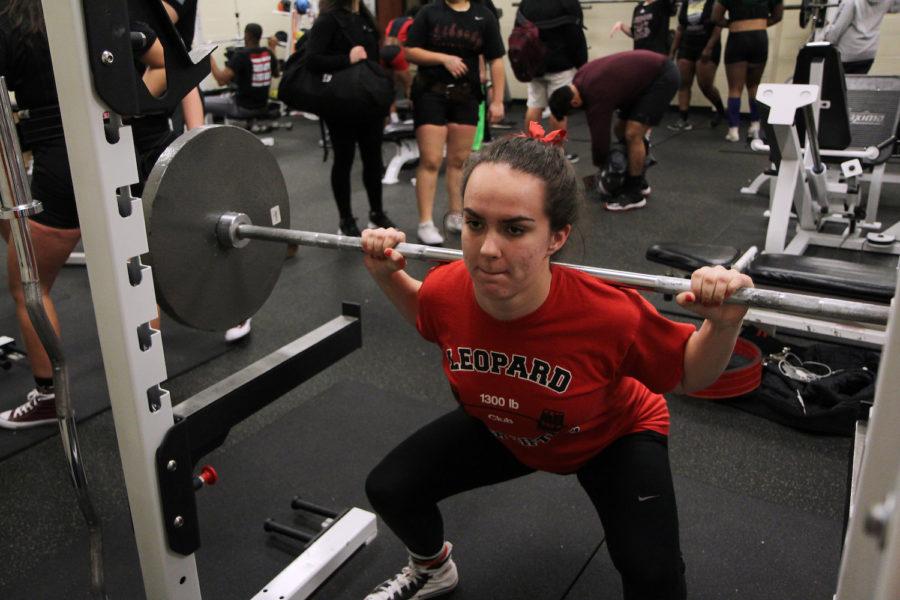 Junior Ally Carraway performs the squat during practice.