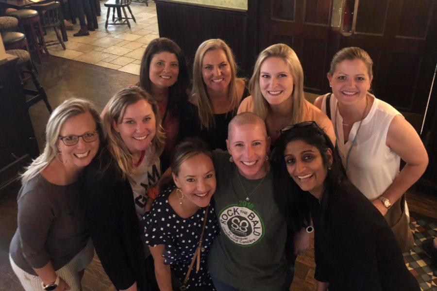 Julie stands surrounded by her friends and supporters after her head was shaved.