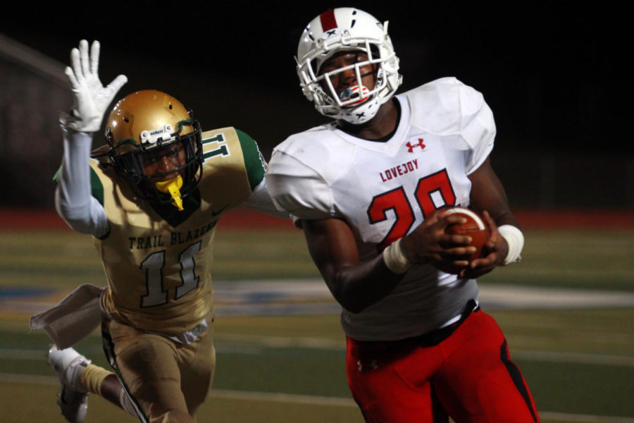 Senior Jahi Rainey rushes down the sidelines in attempt to reach the first down marker avoiding Lebanon Trail defender Vince Pilot.