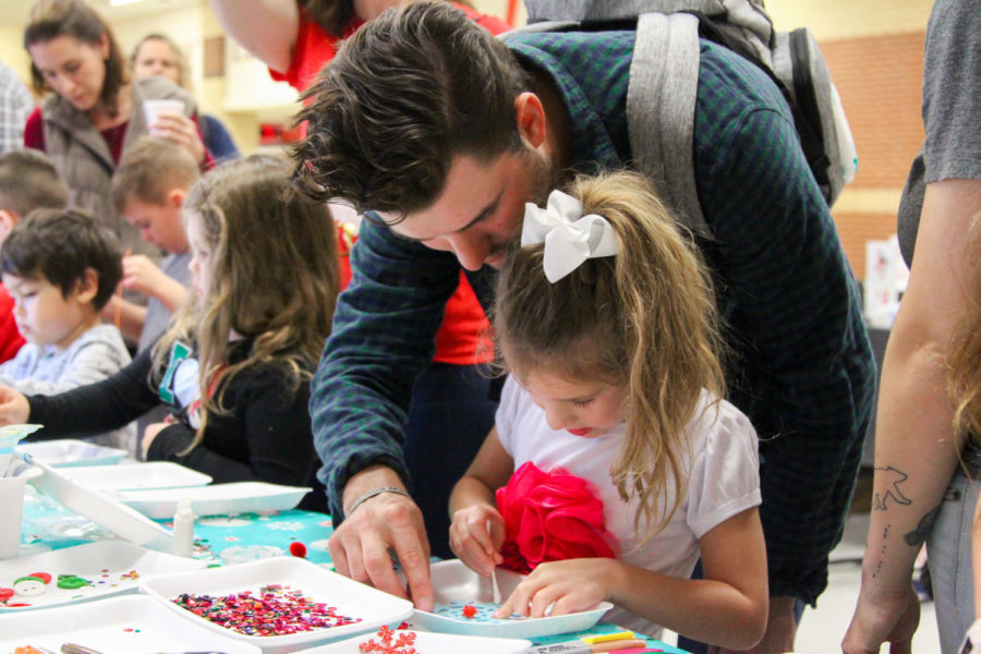 A+little+girl+makes+a+snowflake+craft.