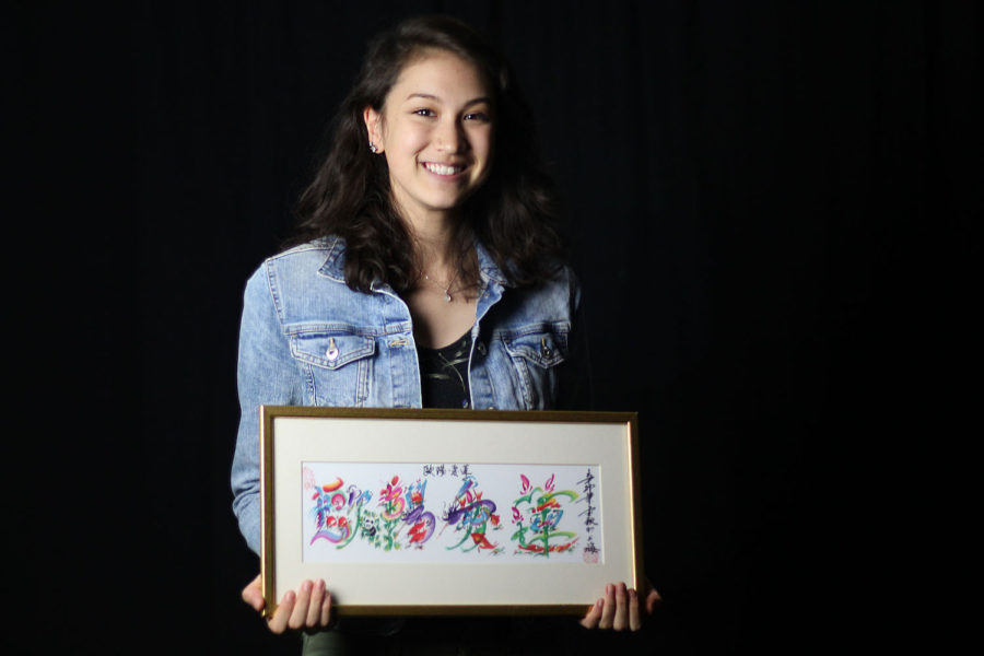 Arianne Ohman poses with a painting of her name in chinese. 