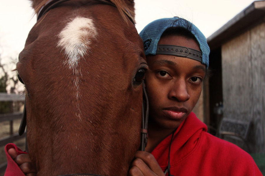 Junior Ty Hall stands with his horse, King, outside the pasture. 