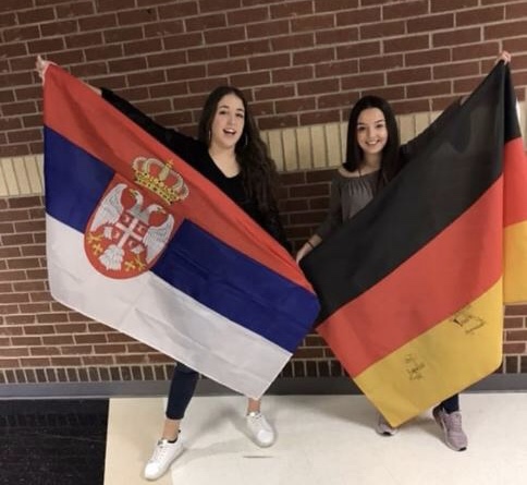 Serbian exchange student Maja Rajevac and German exchange student Melissa Conrad hold their countrys flags. 