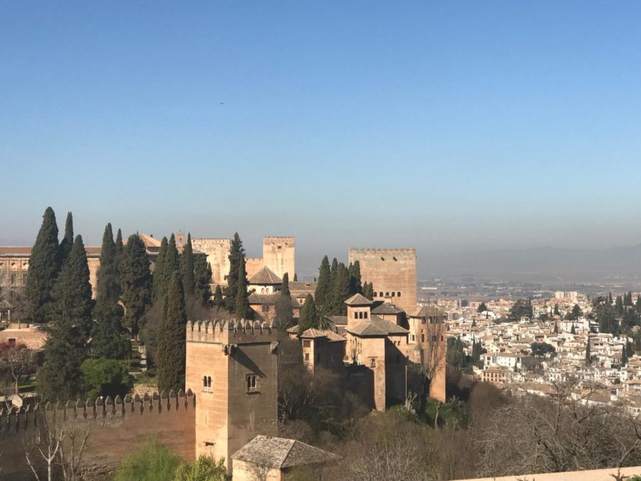 The view overlooking Alhambra from the palace gardens in Granada, Spain shows the city below. The palace was built in the 13 century and reflects Islamic and Christian architecture. 