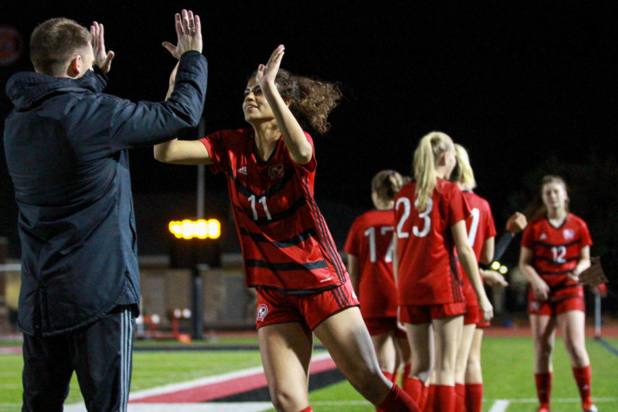 Senior Jessie Maashio high fives head  coach Ian Keeble before the playoff matchup.