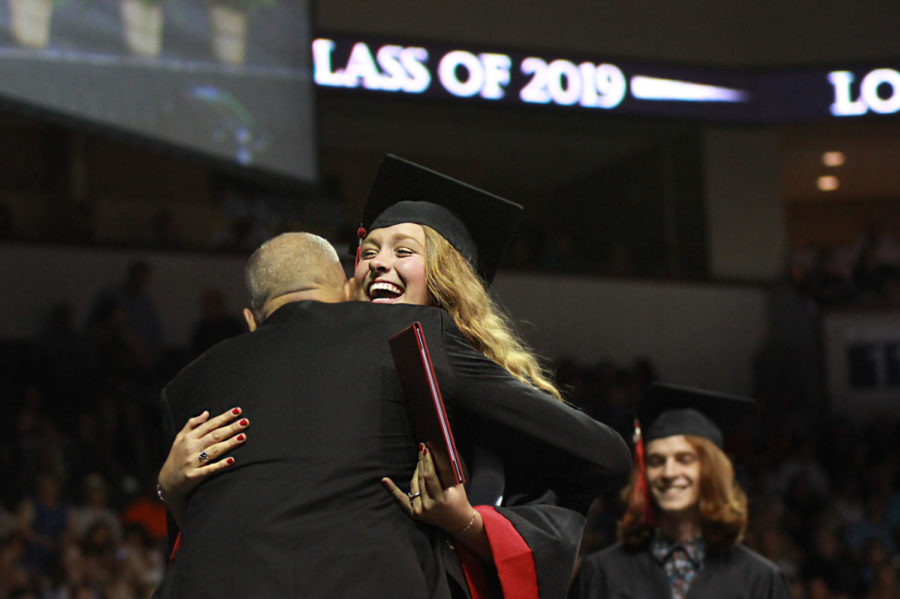Graduate Sarah Collins hugs Principal Chris Mayfield after she receives her diploma. Collins intends on attending  Ouachita Baptist University next fall to study communications and media.  