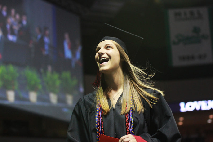 Graduate Haidyn McKenzie beams at her friends and family after receiving her diploma. 