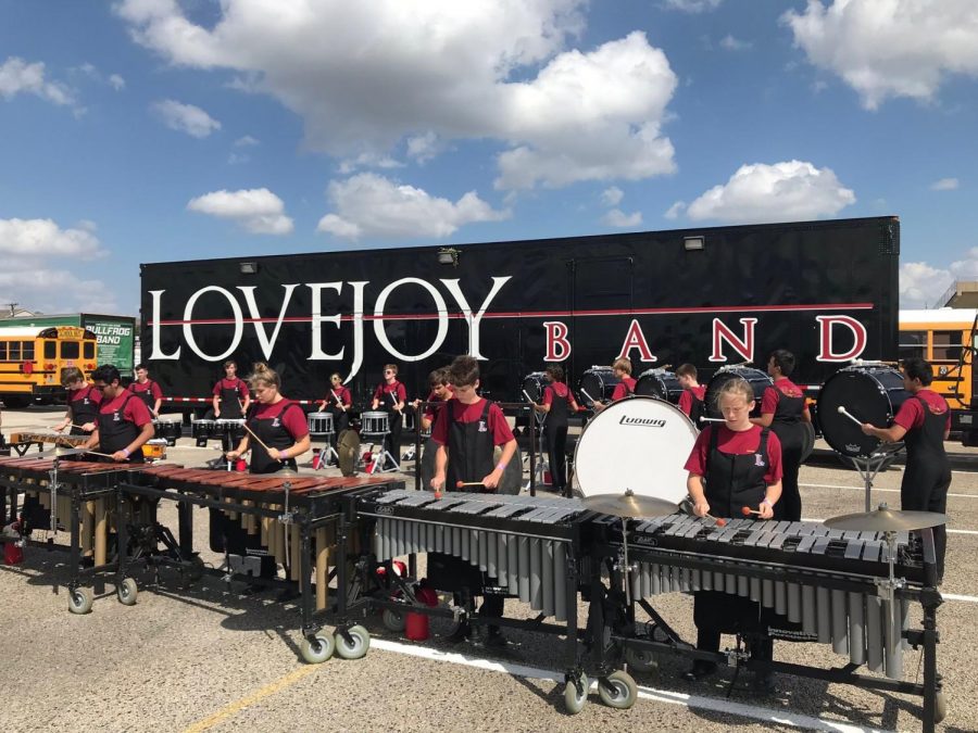 The drumline and front ensemble warm up on a parking lot before performing. The drumline later received a placement of sixth in their division of eight bands.