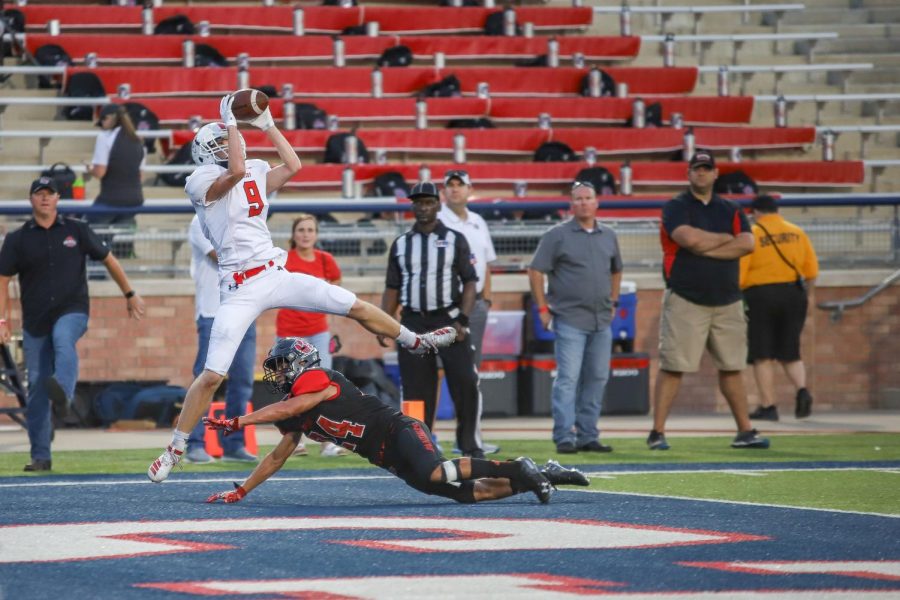 Junior Reid Westervelt elevates above Colleyville Heritage corner back Michael Neves (24) securing the ball for the Leopards first touchdown of the season. 