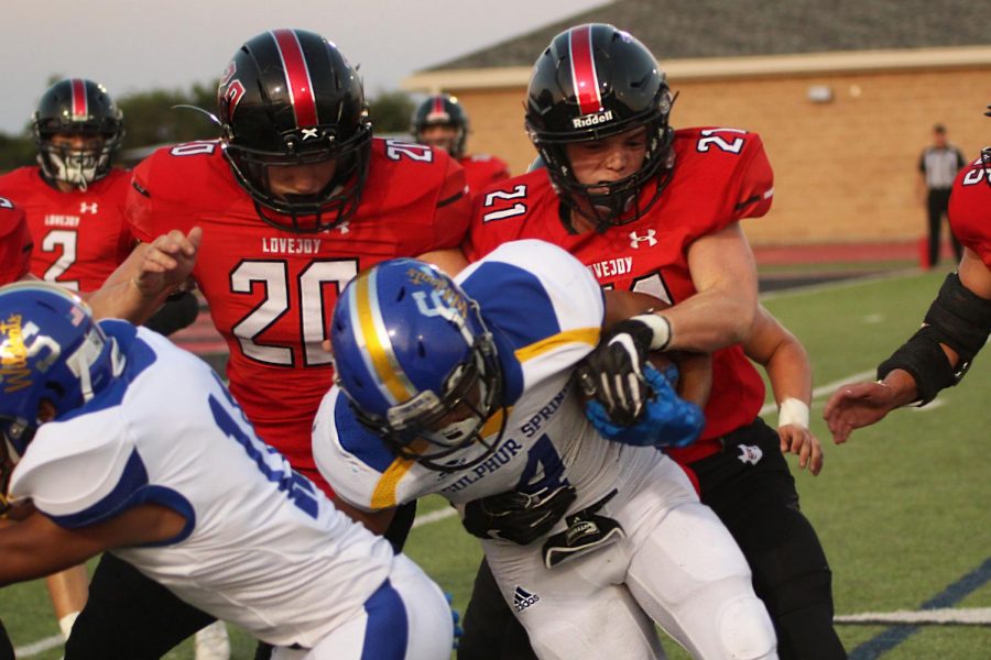 Seniors Austin King and John Ponder tackle Sulphur Springs wide receiver Bryan Sanchez for a loss.