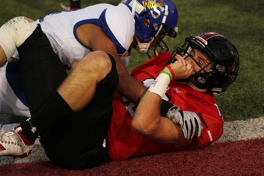 Ralph Rucker recovers from a tackle during the third quarter. Rucker secures his helmet after the fall. 