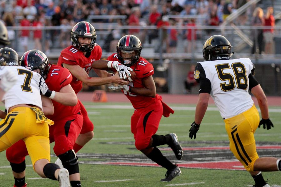 Junior Ralph Rucker hands the ball off to sophomore running back Noah Naidoo. Naidoo carried the ball for a Leopard first down.