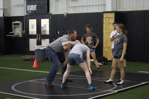 New Performance Course and wrestling coach helps freshman Brindley Eaton and sophomore Avery Ashley practice their wrestling moves. Coach Tischer deostrates on Ella Musselman as he explains the move to Eaton.