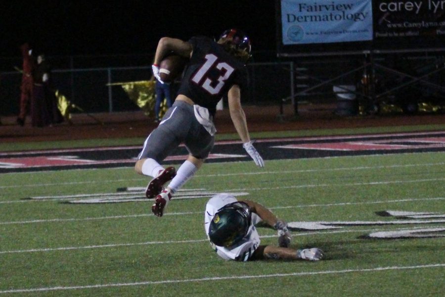 Wide Receiver Luke Mayfield hurdles a Lebanon Trail defensive player to avoid the tackle at the twenty-five yard line. Mayfield eventually scored a touchdown during the third quarter.
