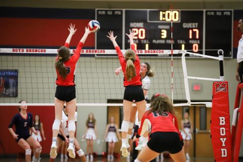 Junior Lexie Collins and sophomore Averi Carlson jump to block the ball from Frisco Centennial's outside hitter.