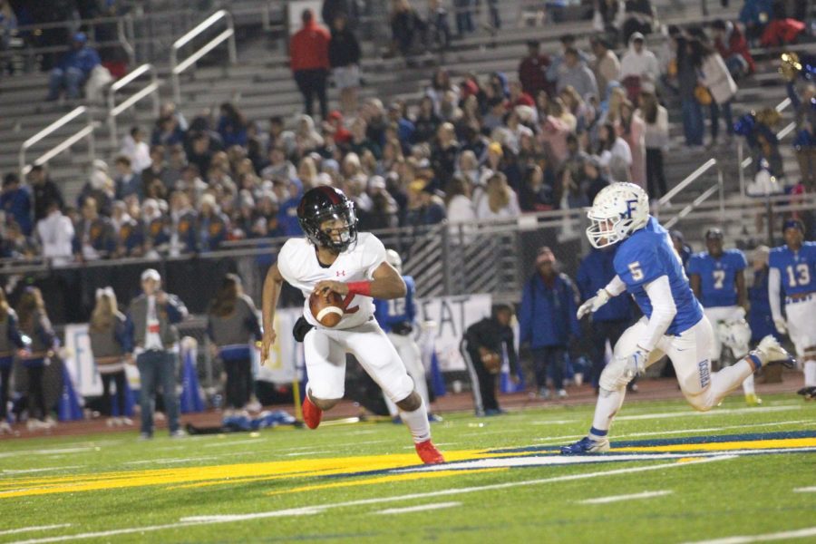 Sophomore Noah Naidoo carries the ball past the 50-yard-line. Naidoo was the fill-in quarterback for the night, as he normally plays as a running back for the Leopards.