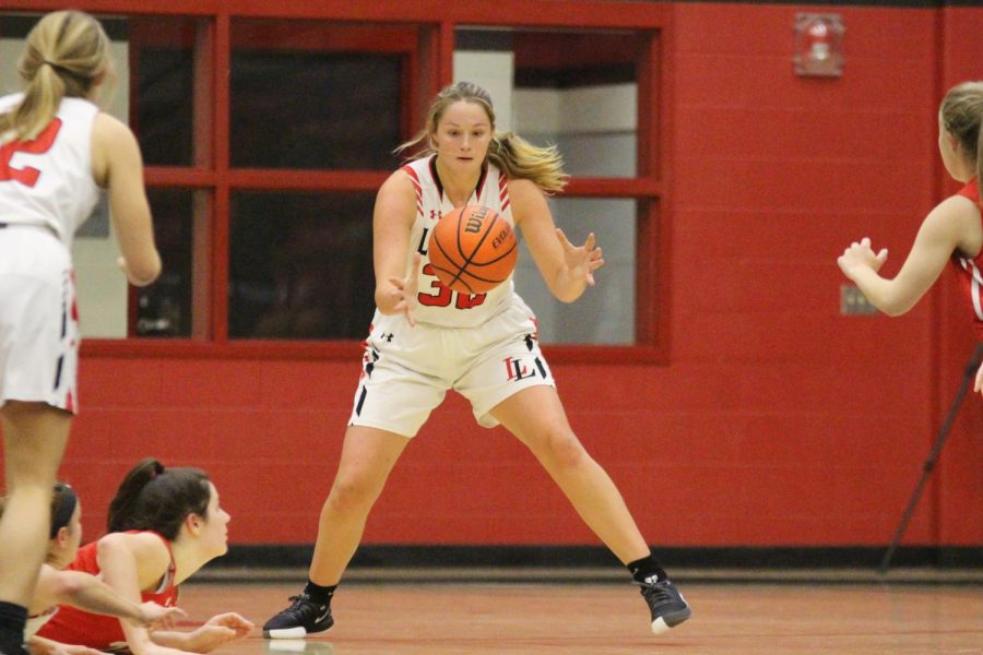 Senior Addison Hand grabs the basketball after junior Julia Brochu tosses the ball up to her.