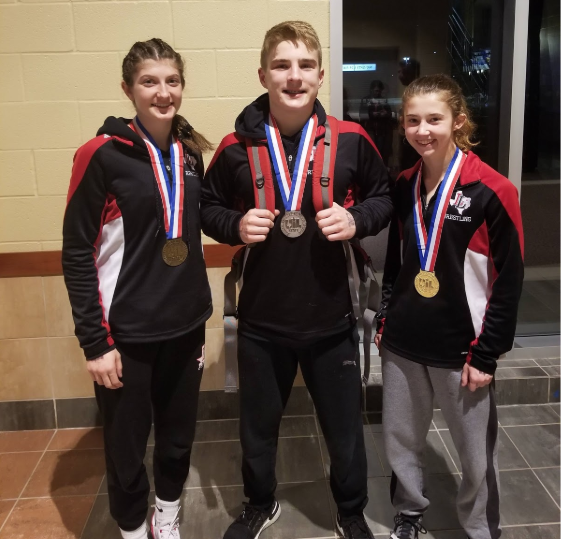 Wrestlers Katherine Heath, Alex Vislosky and Avery Ashley (left to right) finish the UIL wrestling season as winners in their weight classes.