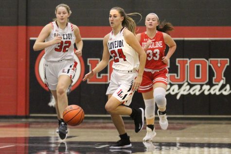 Senior Carsen Mcfadden dribbles the ball past half court in a game against Ursuline.