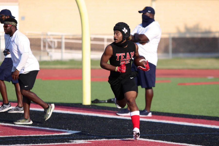 Junior Noah Naidoo runs the ball in after catching a touchdown pass from senior Ralph Rucker. Naidoo also rotated in at quarterback during the scrimmage. 
