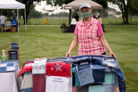 Kay Montgomery stands with her custom jean quilts. She uses old worn out jeans to create quilts, potholders, and other items. 