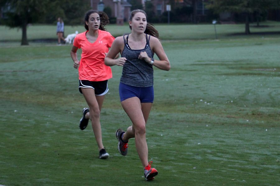 Freshmen Caroline Dolberry and Senior Karly Greenwood run at a team practice. The cross country team practices together at Celebration Park. 