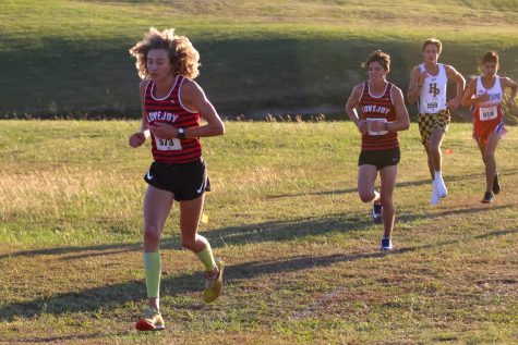 Junior Tate Barr runs up a hill at Myers Park. The high school cross country team won districts in all four races.