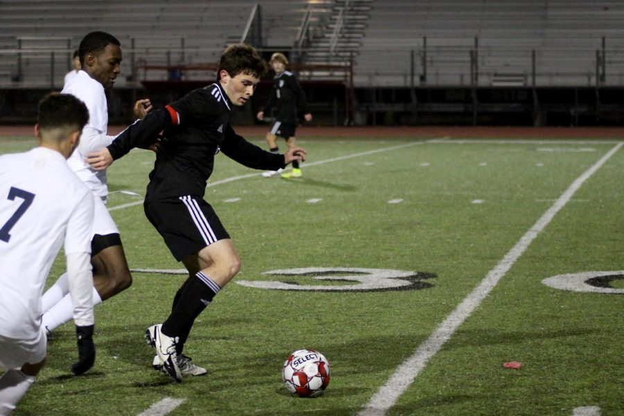 Senior forward no. 3 Michael Myers dribbles the ball out of Raider players. Myers scored two goals of the game. 