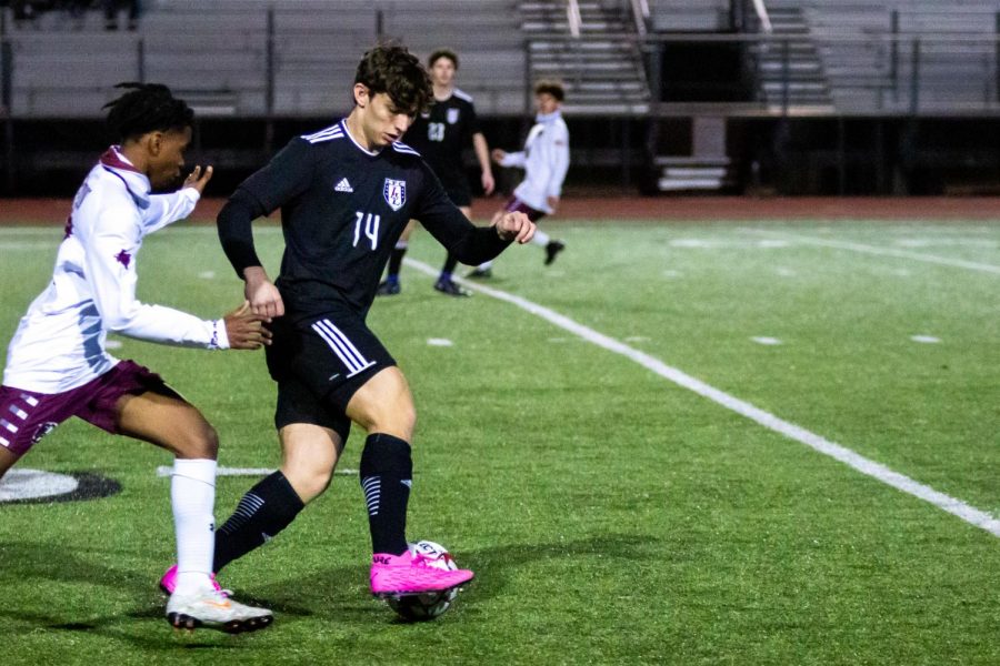 Senior outside midfielder no. 14 Gavin Moore dribbles the ball. Moore is committed to play for Dallas Baptist University in the fall. 