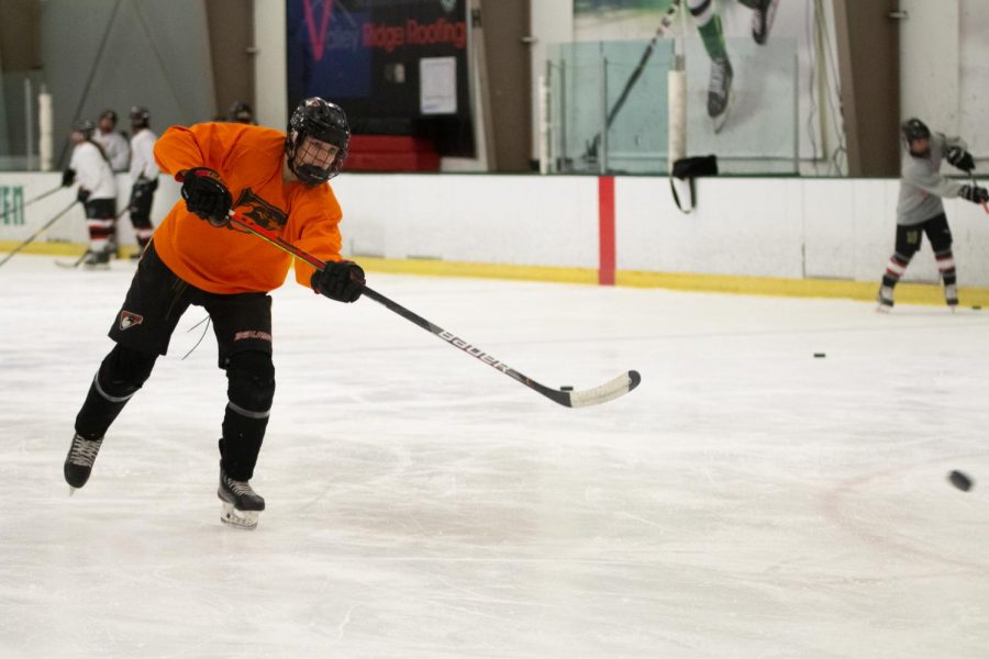 Junior+Andrew+Houser+hits+the+puck+into+the+goal+during+a+practice+drill.+Freshmen+goal+keeper+Christian+Giordano+blocked+this+goal+attempt.+