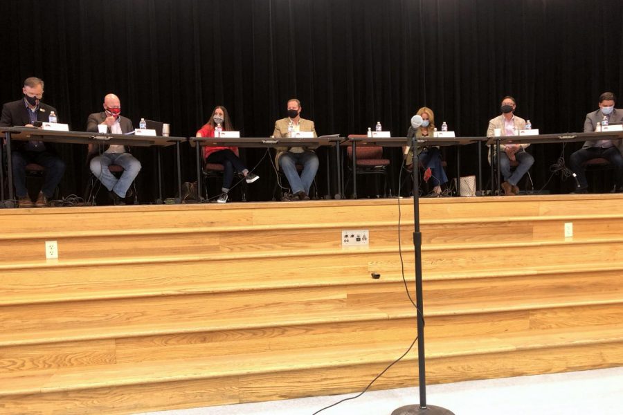 School board of trustees members Marvin Bobo, Barrett Owens, Amy Smith, Chad Collins, Anne Smith, Al Litchenburg and Jeff Wood sit in the Lovejoy Elementary gym. The trustees would announce their decision to keep the mask mandate later that night.