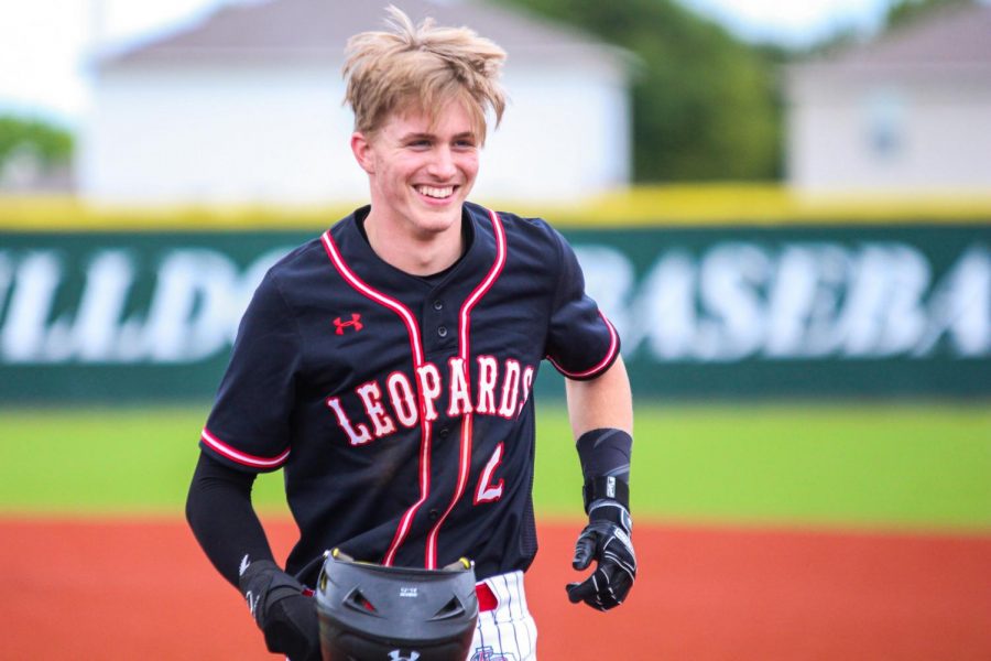 Junior left fielder no. 2 Trent Rucker smiles while jogging off the field after being thrown out at second on a failed double play attempt by the Bulldogs. Rucker got on base after being the second Leopard in row to be hit by a pitch from North’s senior pitcher no. 13 Casey Workman. 
