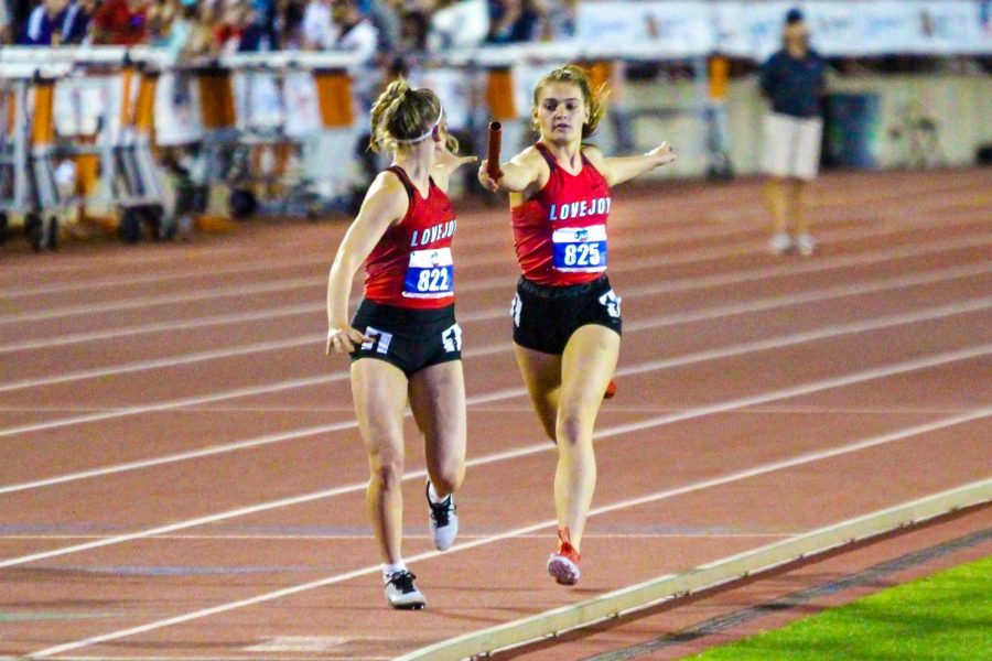 Sophomore sprinter Chloe Schaeffer hands the baton off to sophomore sprinter Bella Landrum. The relay team won district and area and placed second in regionals before qualifying for state. 
