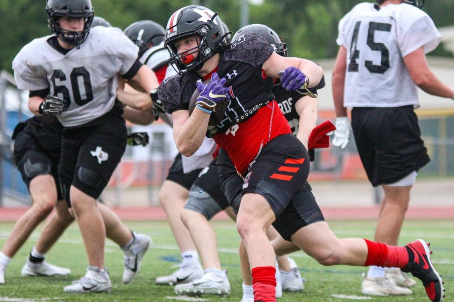 Junior linebacker Phillip Joest runs the ball at spring practice. The football team will play their spring scrimmage on May 22.