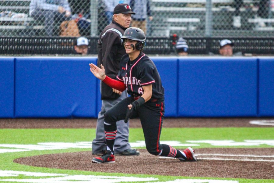 Junior shortstop no. 6 Kolby Branch claps as he slides into home safely to tie the score at one. Branch scored on a fake throw to third base that got away while senior catcher no. 14 Ralph Rucker was up to bat.
