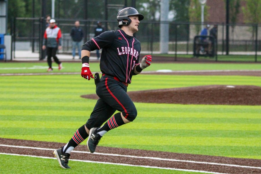 Senior catcher no. 14 Ralph Rucker runs to first base after hitting a pop fly to right-center field. Going into the game, Rucker leads the team in RBIs.