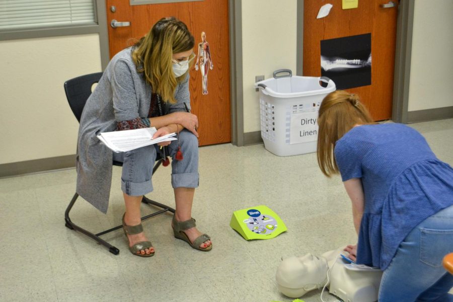 Health Science teacher Kathryn Barnett watches junior Maci Perkins practice for her CPR certification test. Barnett teaches Principles of Health Science, Pharmacy Tech, and part of the CNA Collin College course. 