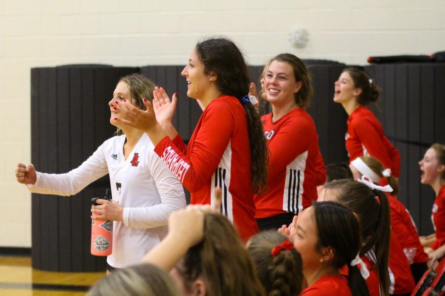 The Leopard’s bench celebrates after scoring a point in the first set. Junior hitter no. 12 Hannah Gonzalez, senior libero no. 7 Ava Camacho, and sophomore outside hitter no. 20 Reagan Fitzsimmons stand to cheer on their team.
