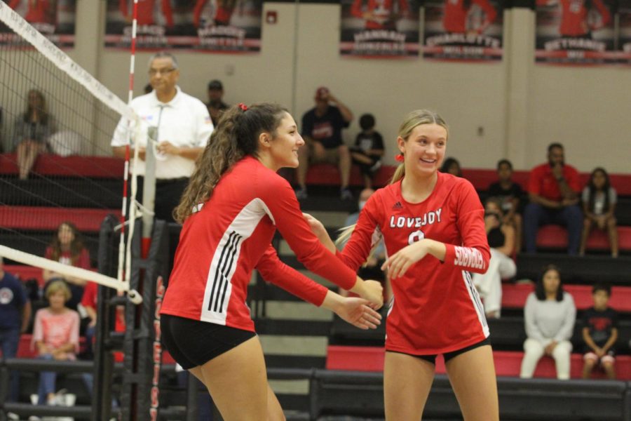 Junior middle hitter no.12 Hannah Gonzalez celebrates with senior setter no. 9 Averi Carlson. The volleyball team will be playing against The Colony on Friday in their first district game.
