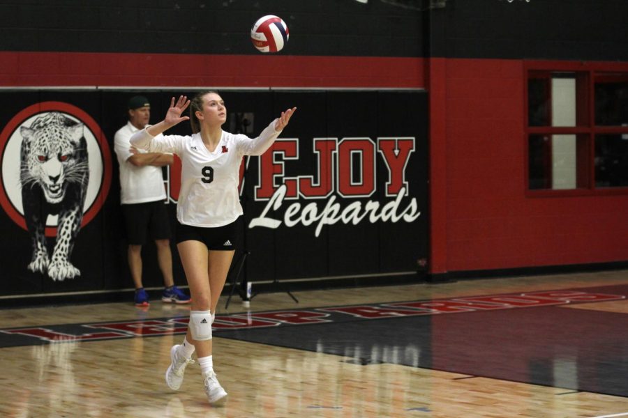 Senior setter no. 9 Averi Carlson serves the ball in the first set. Carlson is committed to continue her volleyball career at Baylor University.