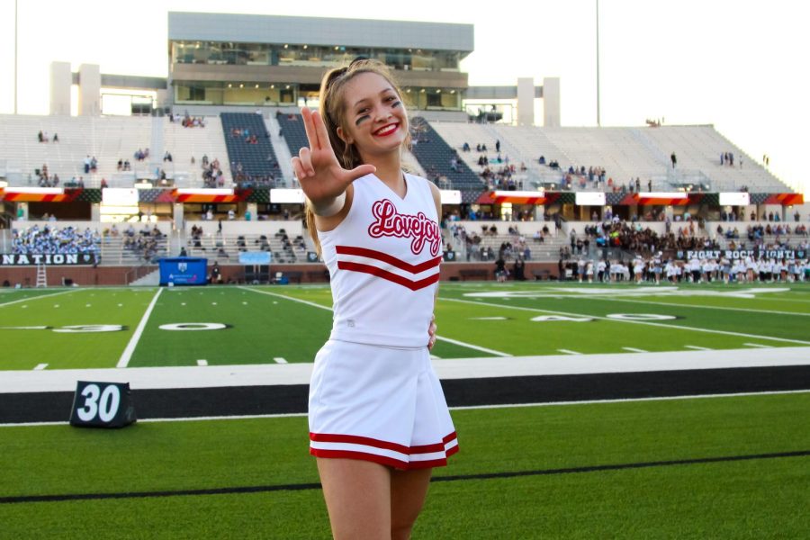 Junior Isabel Szymanski cheers on both the high school varsity team and on Lady Reign at Spirit of Texas. Szymanski has been cheering for seven years.