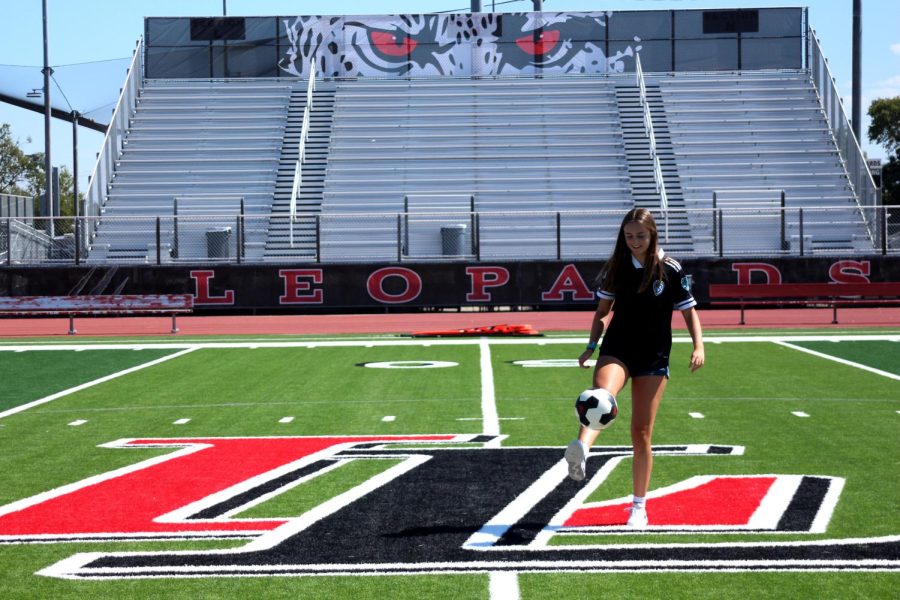 Junior Mary Mueth kicks a soccer ball up into the air. Mueth is on the Sting ENCL club team.