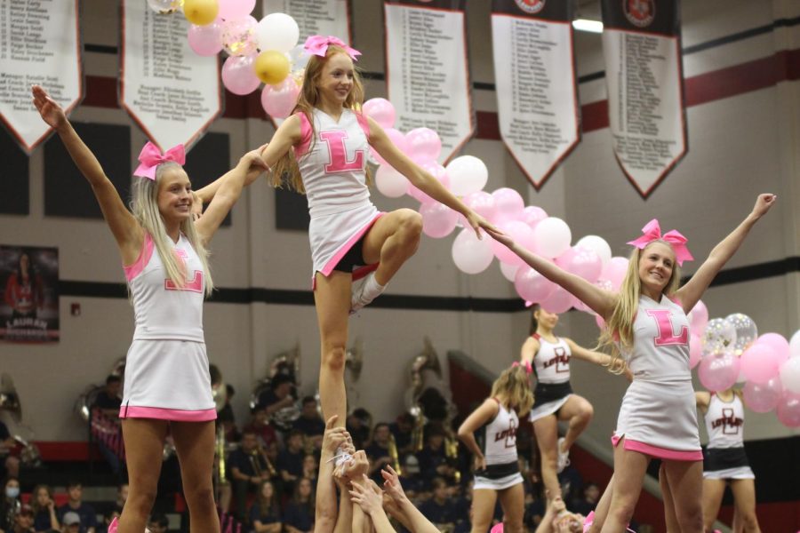 Junior Taylor Reiner and senior Ashley Ludlow hold up senior Claire Traylor in a pyramid. The cheerleaders performed a tumbling and stunting routine in the pep rally.