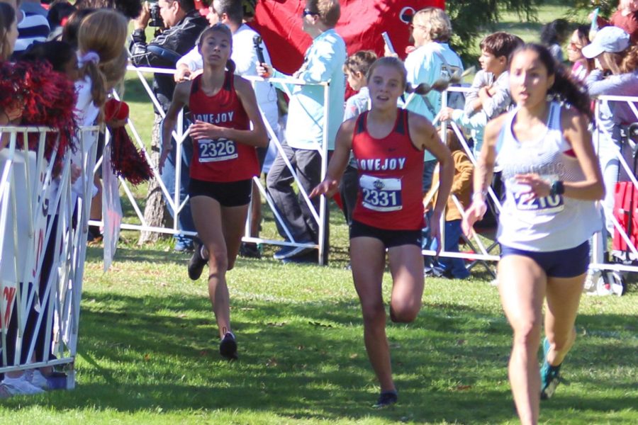 Sophomores Peyton Benson and Sara Morfield turn the corner for the last stretch of the race. The two runners came in 12th and 13th place, respectively.