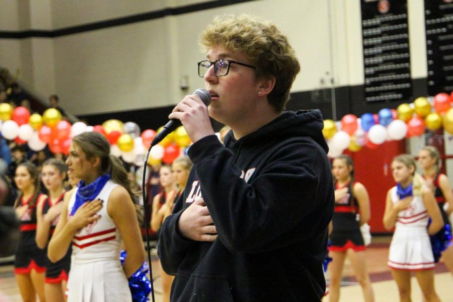 Senior Ian York sings the national anthem. York is a part of the a capella group.