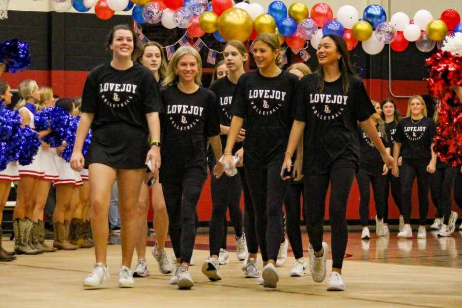 The varsity volleyball team walks into the gym at the pep rally. The volleyball team is currently competing in playoffs.